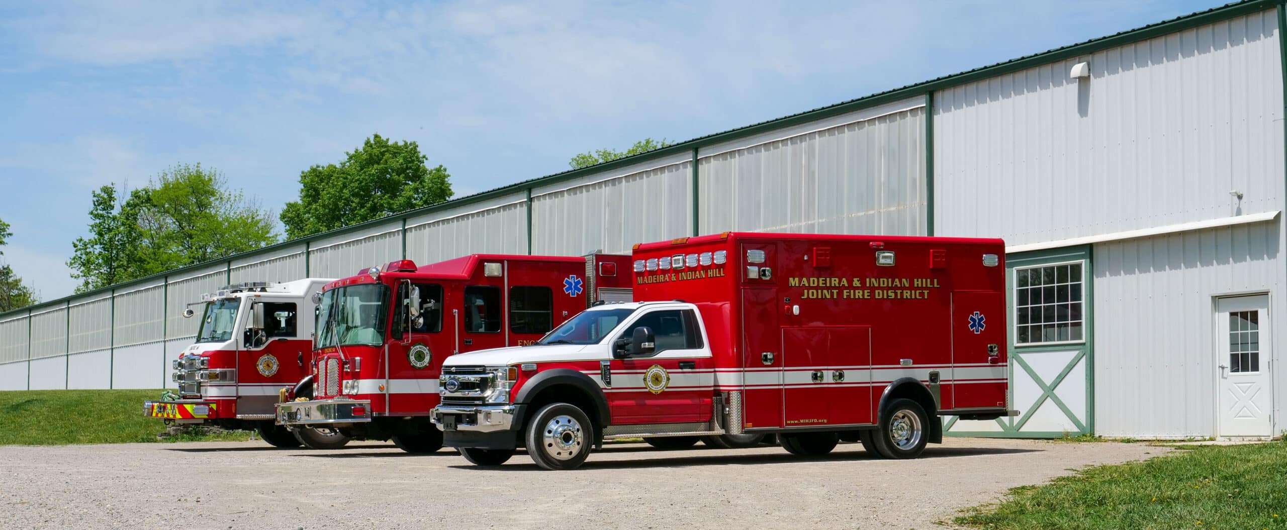 Fire trucks and ambulance parked outside of Greenacres Equine Center indoor riding arena.