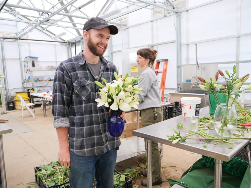 Garden Apprentice arranging flower bouquets in greenhouse