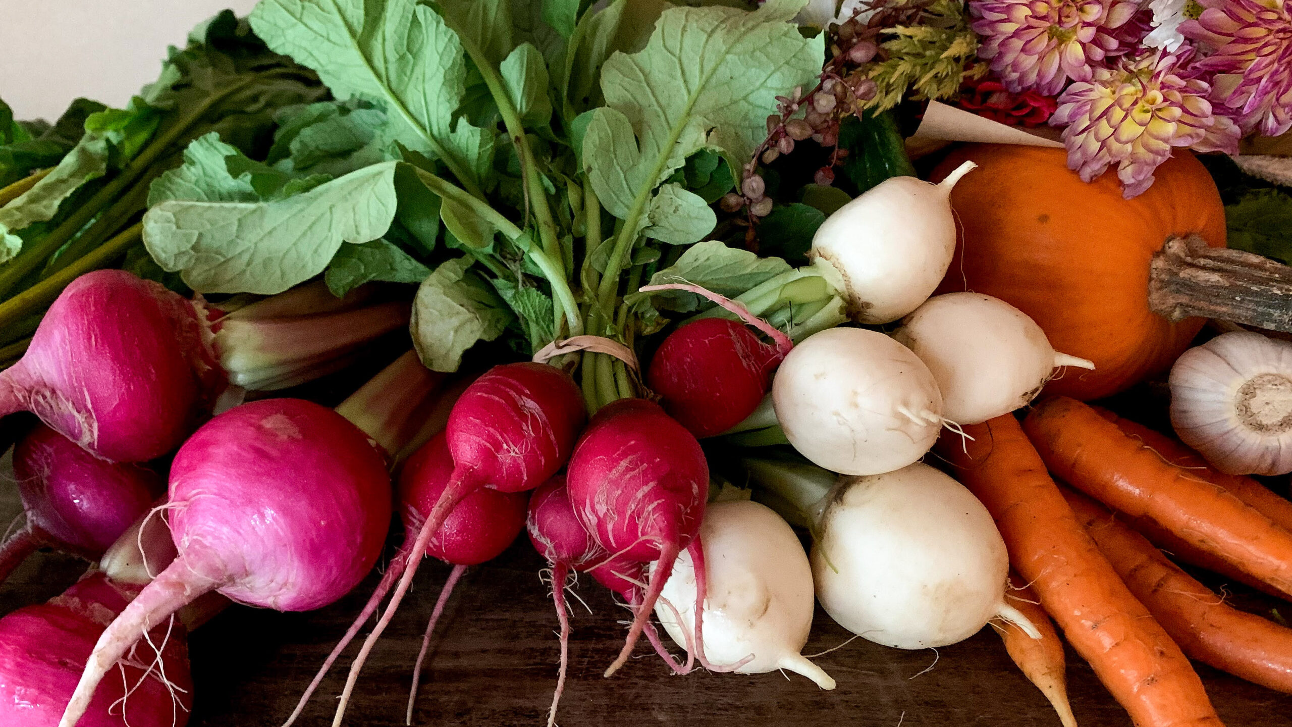 Fresh greens, beets, radishes, turnips, carrots, garlic, pumpkin, and flowers